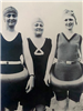 Black and white photo of people wearing bathing suits and flotation devices