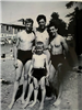 Black and white photo of people in bathing suits posing for photo