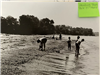Black and white photo of people on the beach in the 1960s