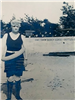 Black and white photo of person wearing bathing suit and flotation device at the beach