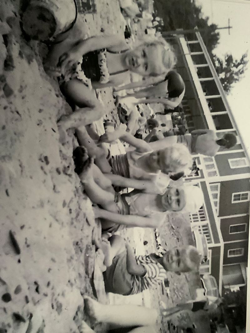 Black and white photo of kids playing together on the beach