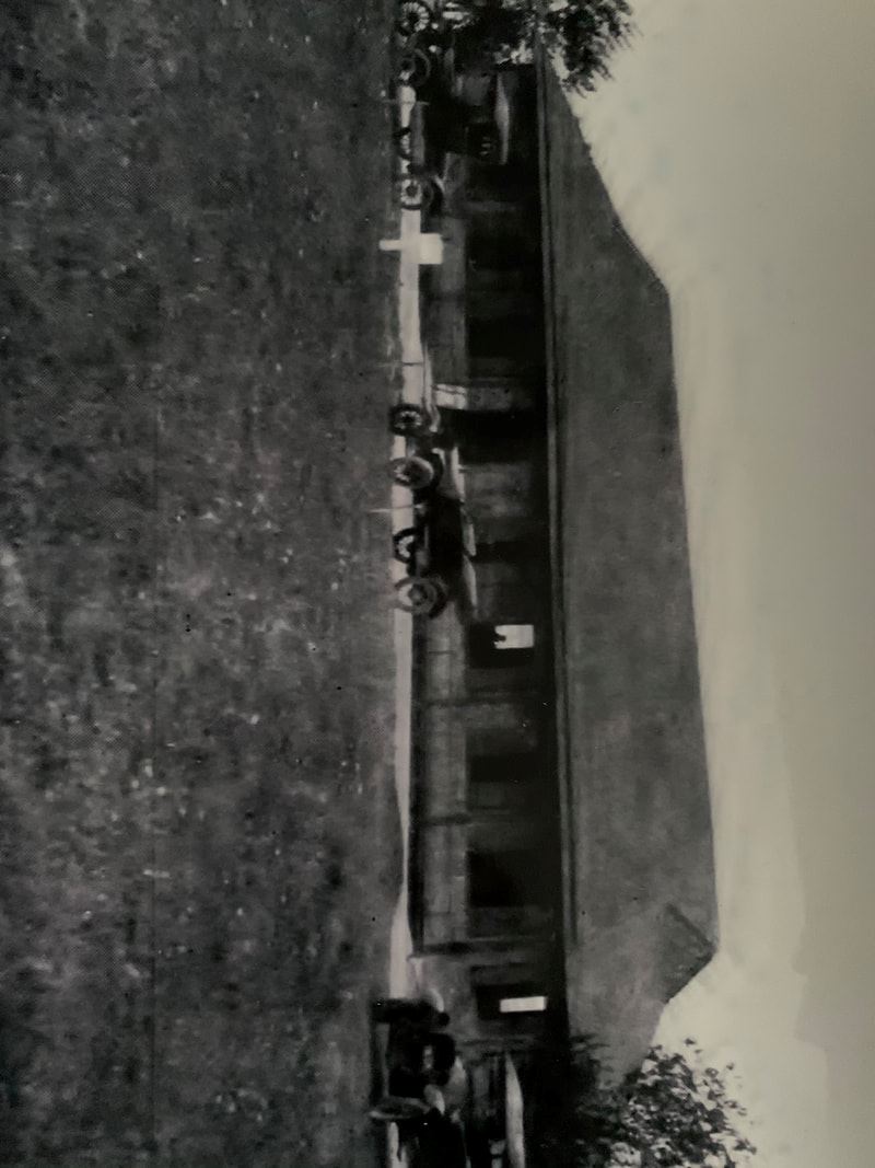Black and white photo of bath house and cars at the beach