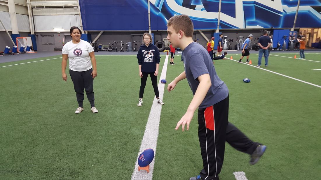 Youth at Football Stadium Kicking Football
